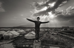 A boy plays on ruins at Domiz refugee camp. © Sean Sutton/CMC/MAG