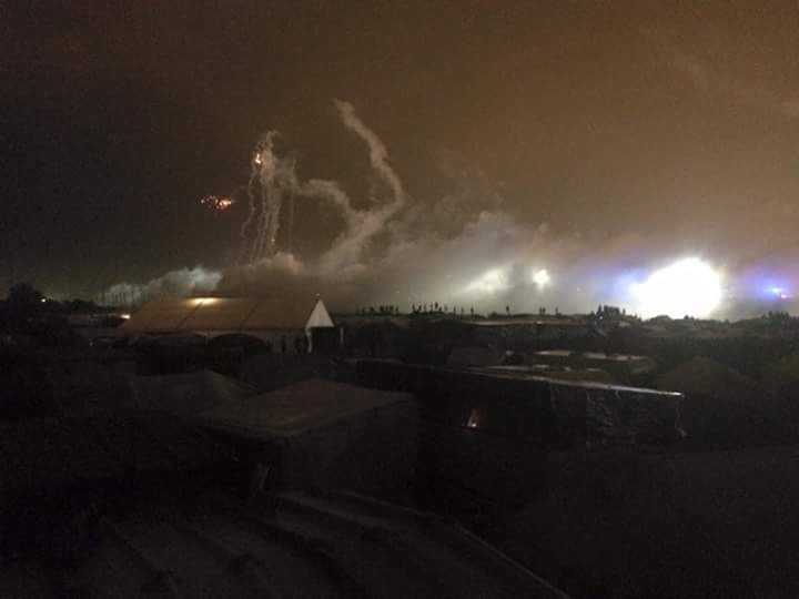Au fond la rocade portuaire et les spots des projecteurs de la police. Les tirs de grenades dans le ciel et les nuages de gaz au sol. Photo prise par des militant-e-s calaisien-ne-s.